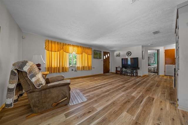 23737 NW Mallard Ave, Dunnellon, FL 34431 - living area with light wood finished floors, a textured ceiling, baseboards, and visible vents