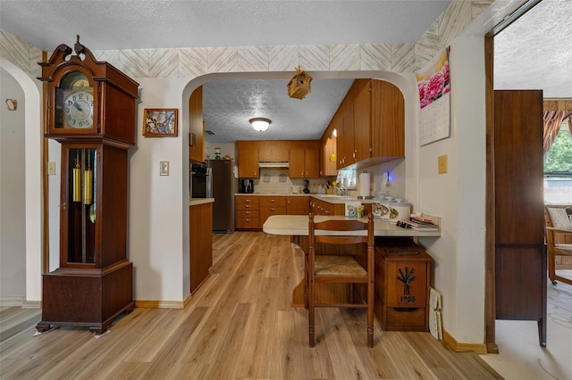 23737 NW Mallard Ave, Dunnellon, FL 34431 - kitchen with a textured ceiling, arched walkways, light countertops, and appliances with stainless steel finishes