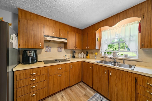 23737 NW Mallard Ave, Dunnellon, FL 34431 - kitchen featuring freestanding refrigerator, a textured ceiling, under cabinet range hood, a sink, and light countertops
