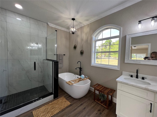 13430 NE 30th Ct, Anthony, FL 32617 - bathroom featuring wood finished floors, a marble finish shower, a soaking tub, vanity, and ornamental molding