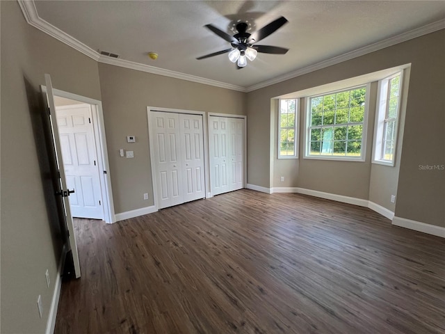 13430 NE 30th Ct, Anthony, FL 32617 - unfurnished bedroom with two closets, crown molding, dark wood finished floors, baseboards, and ceiling fan