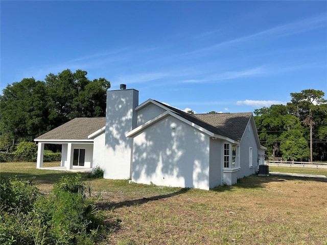 13430 NE 30th Ct, Anthony, FL 32617 - view of side of home featuring a chimney and central AC unit
