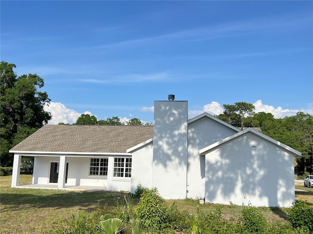 13430 NE 30th Ct, Anthony, FL 32617 - back of house featuring a chimney, a patio, a lawn, and stucco siding