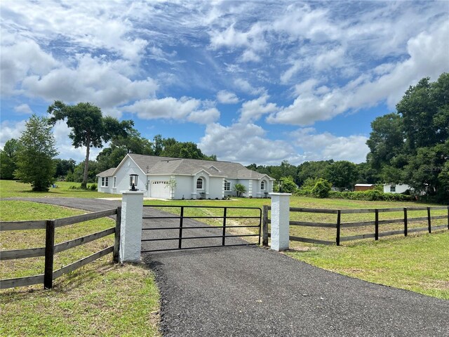 13430 NE 30th Ct, Anthony, FL 32617 - ranch-style house featuring driveway, a garage, stucco siding, and a gate