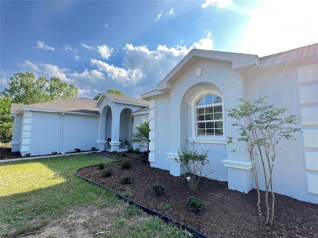 13430 NE 30th Ct, Anthony, FL 32617 - view of front of home with stucco siding, a front lawn, and roof with shingles