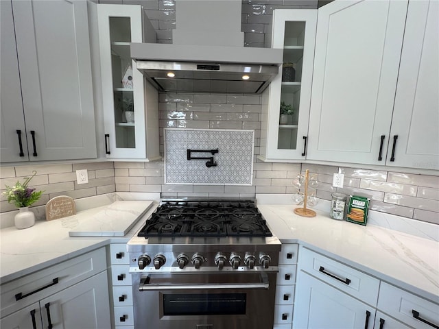13430 NE 30th Ct, Anthony, FL 32617 - kitchen with stainless steel stove, wall chimney exhaust hood, backsplash, and glass insert cabinets