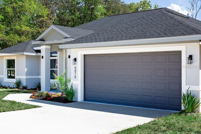 single story home featuring roof with shingles, an attached garage, stucco siding, and driveway