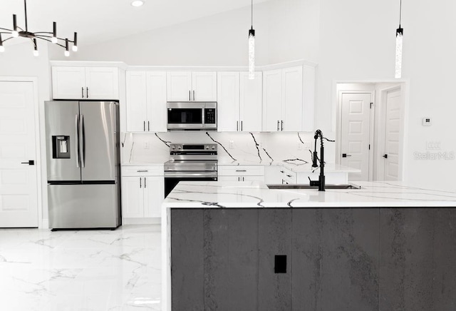 kitchen with marble finish floor, a sink, white cabinets, appliances with stainless steel finishes, and light stone counters
