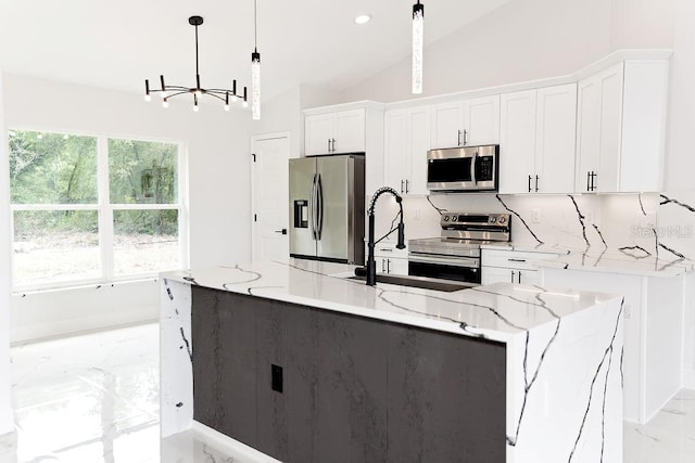 kitchen with a notable chandelier, marble finish floor, white cabinetry, vaulted ceiling, and appliances with stainless steel finishes