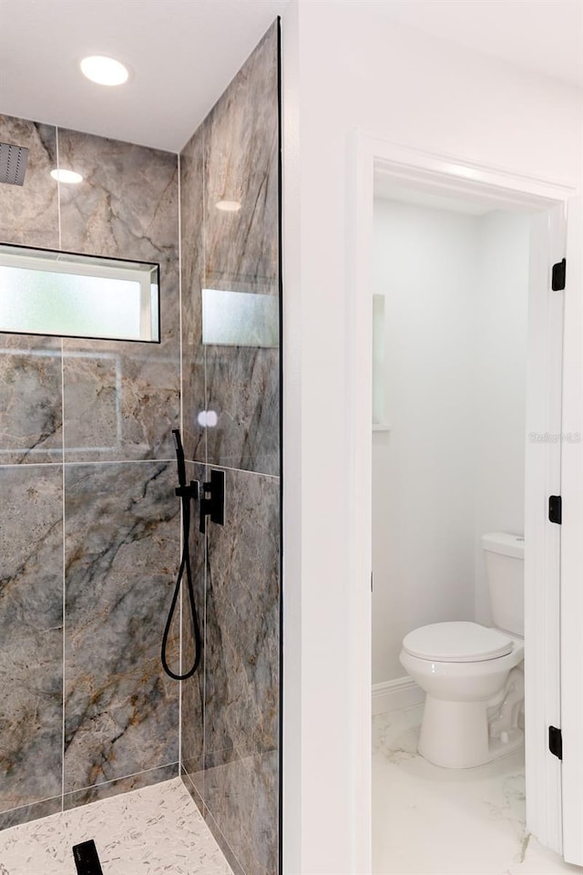 bathroom with toilet, marble finish floor, and walk in shower