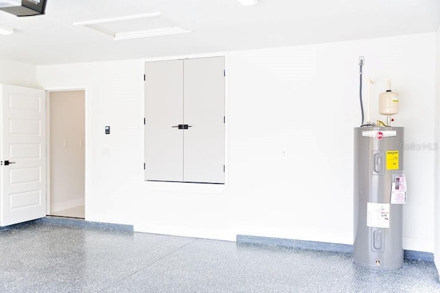 garage featuring electric water heater, baseboards, and a garage door opener