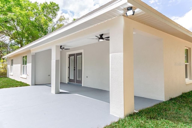 rear view of property with a patio area, stucco siding, french doors, and ceiling fan