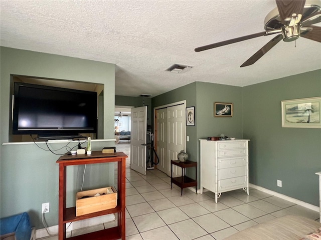 16850 SE 19th Ct, Summerfield, FL 34491 - bedroom with light tile patterned floors, a closet, a ceiling fan, a textured ceiling, and baseboards