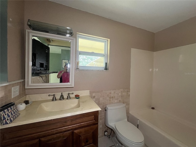 16850 SE 19th Ct, Summerfield, FL 34491 - full bathroom with toilet, vanity, tile walls, bathtub / shower combination, and wainscoting