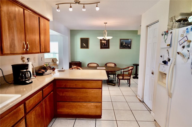 16850 SE 19th Ct, Summerfield, FL 34491 - kitchen with white fridge with ice dispenser, a peninsula, brown cabinets, light tile patterned floors, and light countertops