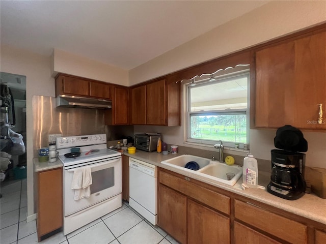 16850 SE 19th Ct, Summerfield, FL 34491 - kitchen with white appliances, under cabinet range hood, a sink, light tile patterned floors, and light countertops
