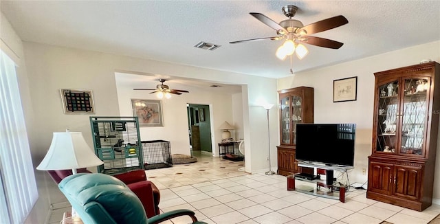 16850 SE 19th Ct, Summerfield, FL 34491 - living room with ceiling fan, a textured ceiling, light tile patterned floors, and baseboards
