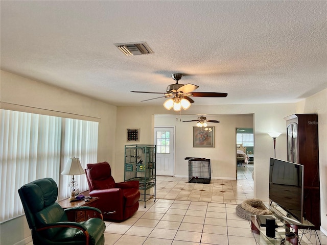 16850 SE 19th Ct, Summerfield, FL 34491 - living area featuring ceiling fan, light tile patterned floors, a textured ceiling, and baseboards