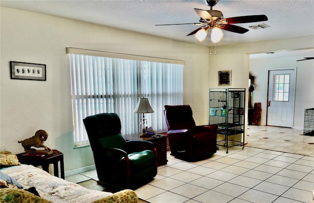 16850 SE 19th Ct, Summerfield, FL 34491 - living room with a ceiling fan, a textured ceiling, baseboards, and light tile patterned floors