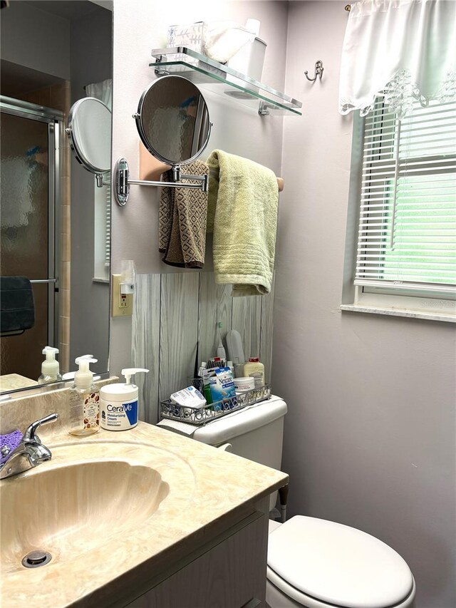 bathroom featuring vanity, toilet, and a stall shower