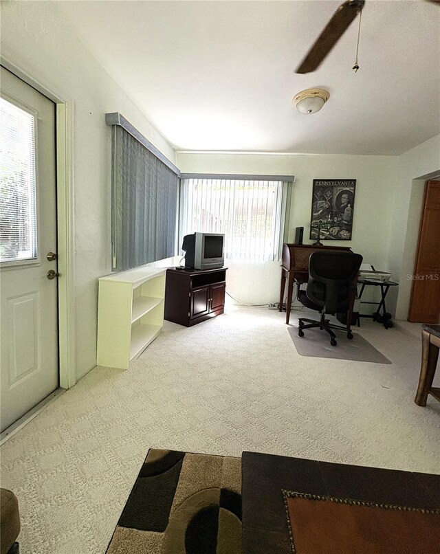 carpeted office featuring ceiling fan