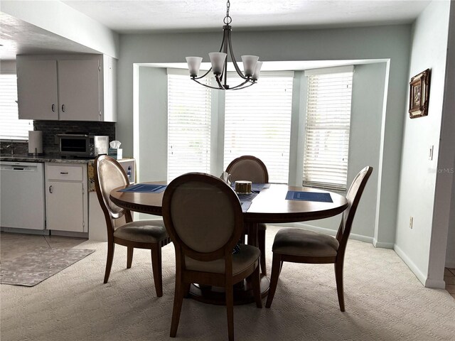 dining area featuring an inviting chandelier, plenty of natural light, and light colored carpet