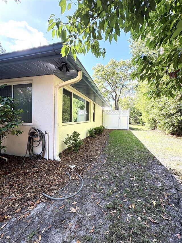 view of home's exterior with fence and stucco siding