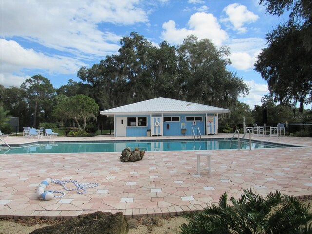 pool with a patio and fence