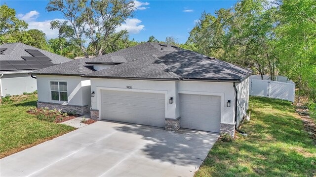 view of front facade with roof with shingles, fence, concrete driveway, an attached garage, and stucco siding