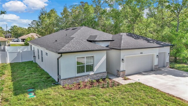 view of side of home featuring an attached garage, stucco siding, driveway, and fence