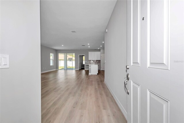 interior space featuring recessed lighting, baseboards, visible vents, and light wood-style floors