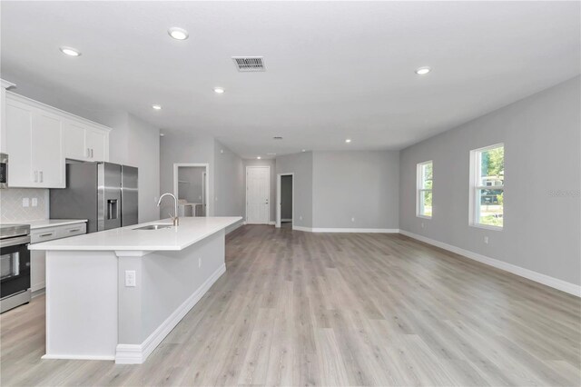 kitchen featuring visible vents, appliances with stainless steel finishes, a sink, light countertops, and white cabinets