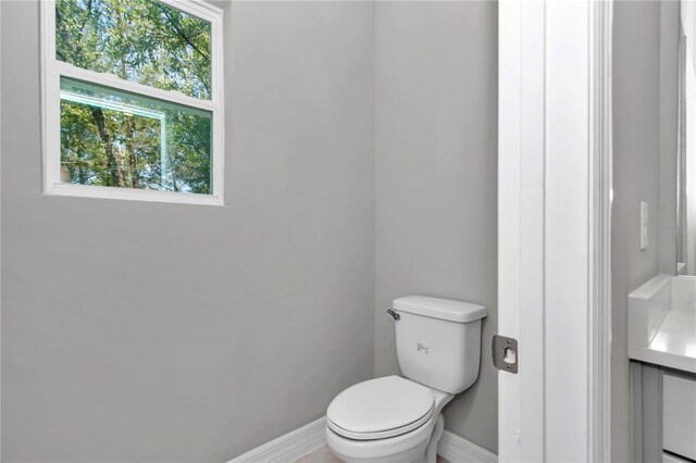bathroom featuring baseboards, vanity, and toilet