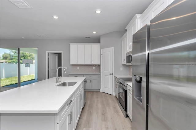 9405 SE 159th Ln, Summerfield, FL 34491 - kitchen featuring appliances with stainless steel finishes, a sink, light wood-style floors, light countertops, and backsplash