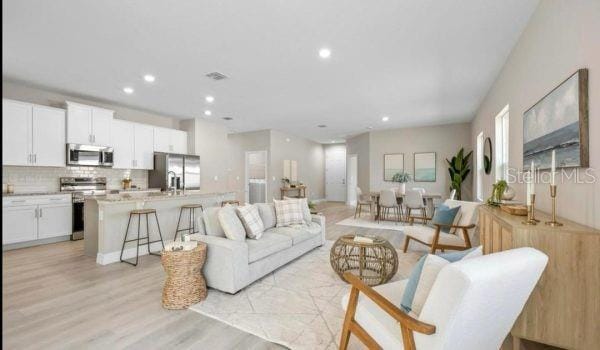 9405 SE 159th Ln, Summerfield, FL 34491 - living room with light wood-style floors and recessed lighting
