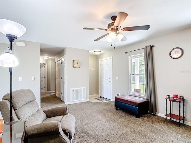 carpeted living room featuring a ceiling fan and baseboards