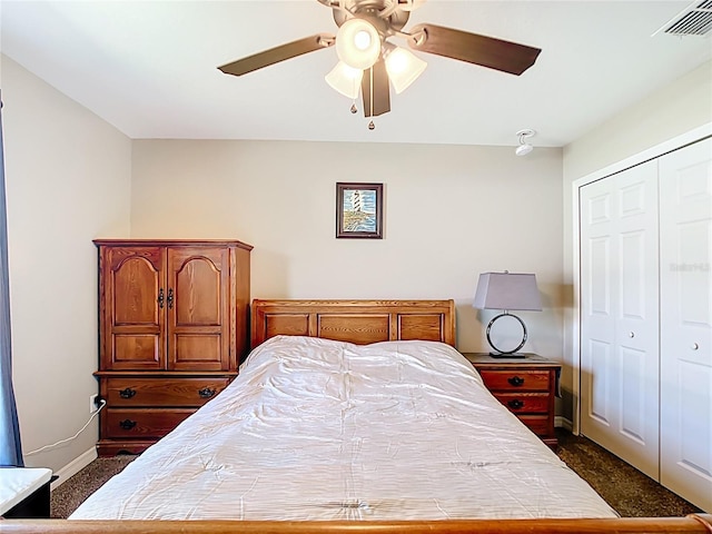 bedroom with a closet, dark carpet, baseboards, and a ceiling fan