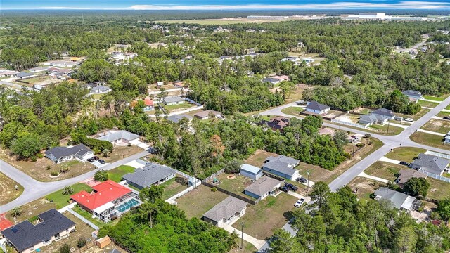 aerial view of property's location featuring a heavily wooded area and nearby suburban area