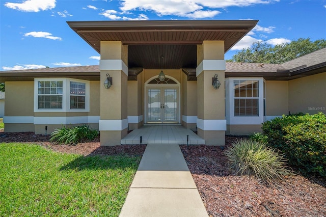 property entrance featuring stucco siding and french doors