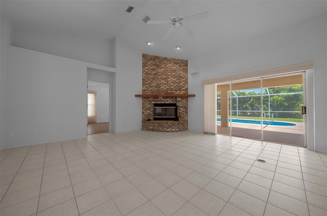 unfurnished living room with a ceiling fan, visible vents, a brick fireplace, light tile patterned floors, and high vaulted ceiling