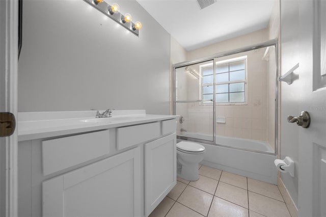 full bath with visible vents, tile patterned floors, vanity, toilet, and shower / bath combination with glass door
