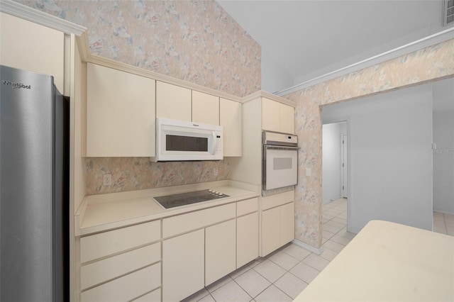 kitchen featuring white appliances, wallpapered walls, light countertops, cream cabinets, and light tile patterned floors