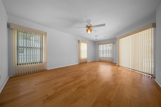 spare room featuring a ceiling fan, baseboards, and light wood-style flooring