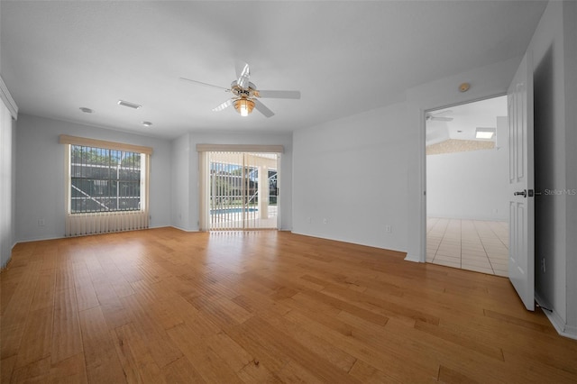 unfurnished room with ceiling fan, visible vents, and light wood-style flooring