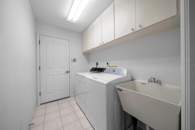 laundry room featuring cabinet space, light tile patterned floors, a sink, and washer and clothes dryer