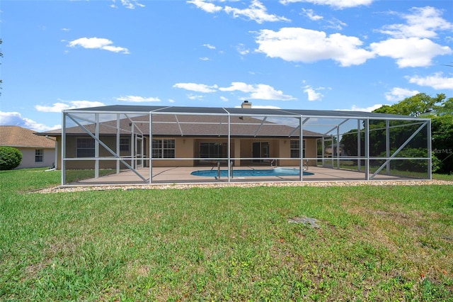 rear view of house with a lawn, an outdoor pool, a patio area, and stucco siding