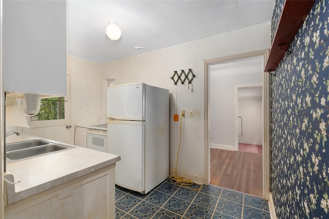 608 SE 31st Ter, Ocala, FL 34471 - kitchen with wallpapered walls, baseboards, white appliances, a sink, and light countertops