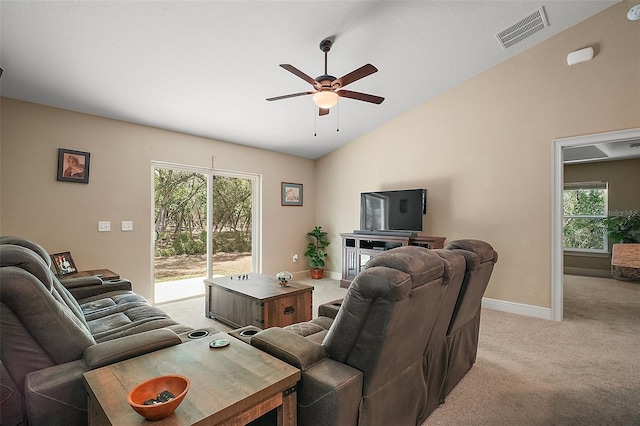 living room featuring ceiling fan, visible vents, lofted ceiling, light carpet, and a wealth of natural light