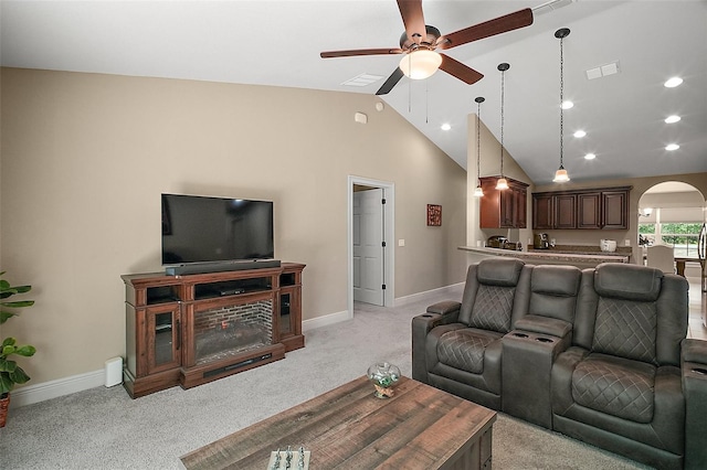 living room with visible vents, baseboards, ceiling fan, light colored carpet, and arched walkways