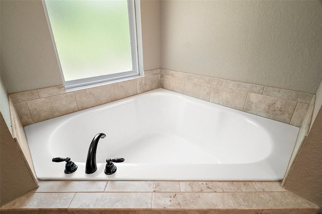 full bathroom with a textured wall and a bath